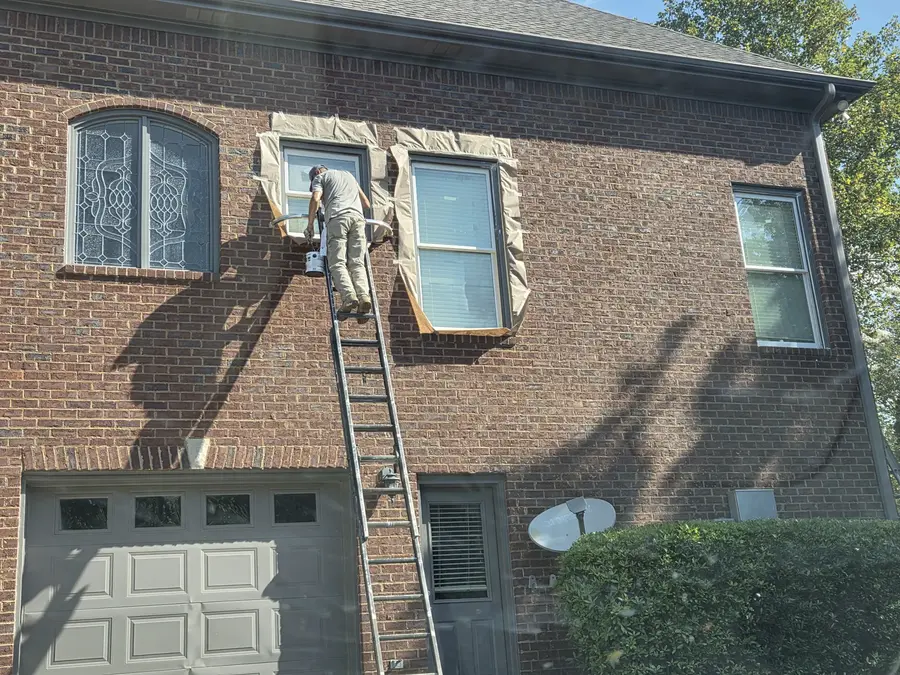 Painting in the South crew working on second-story exterior window trim