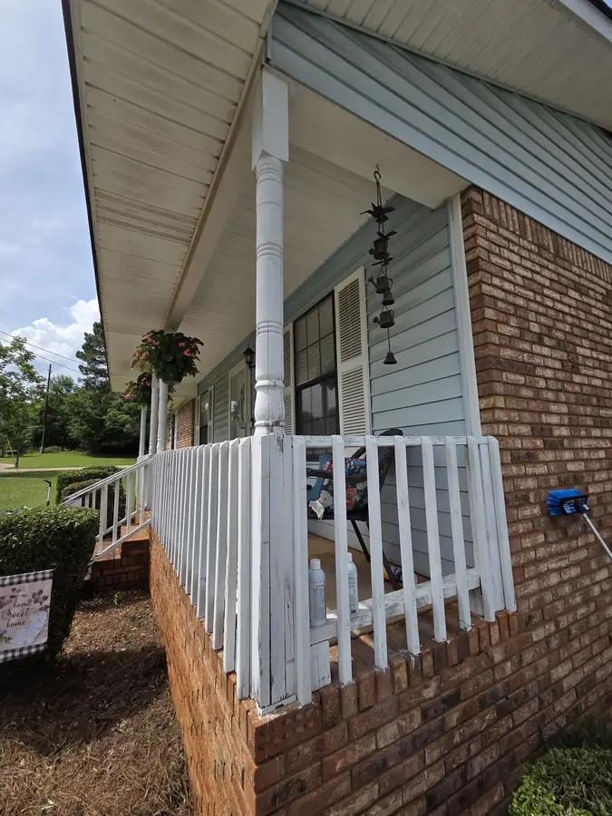 Repaired and painted white front porch railing