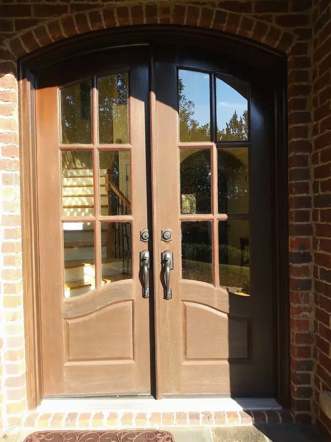 Refinished double front entry doors on a brick home