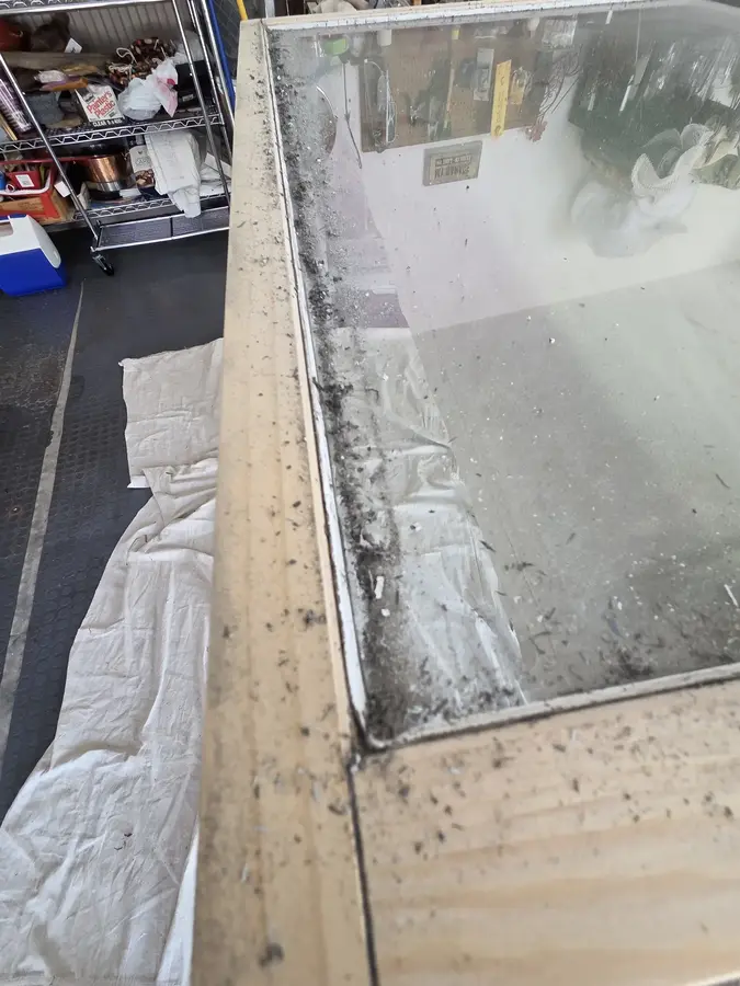 Damaged wood window frame stripped for repair and refinishing